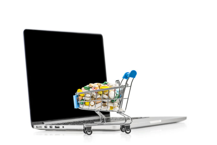 Shopping cart with different tablets near notebook. Purchase of Shopping cart with different tablets near notebook. Purchase of